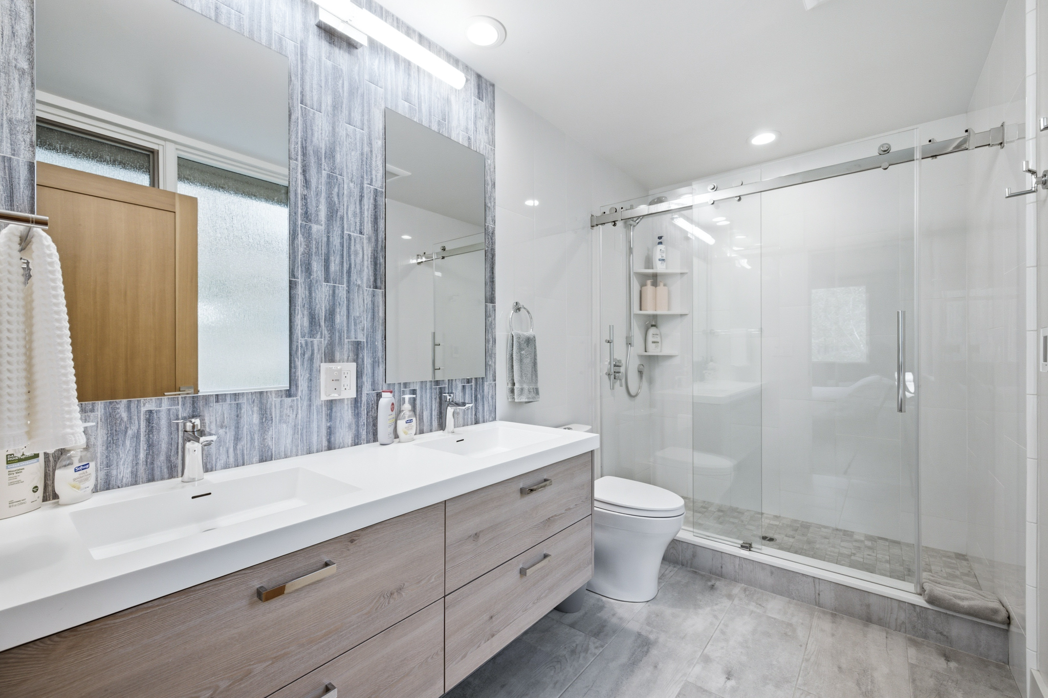 Master bathroom with double vanity, slate tile, and glass shower