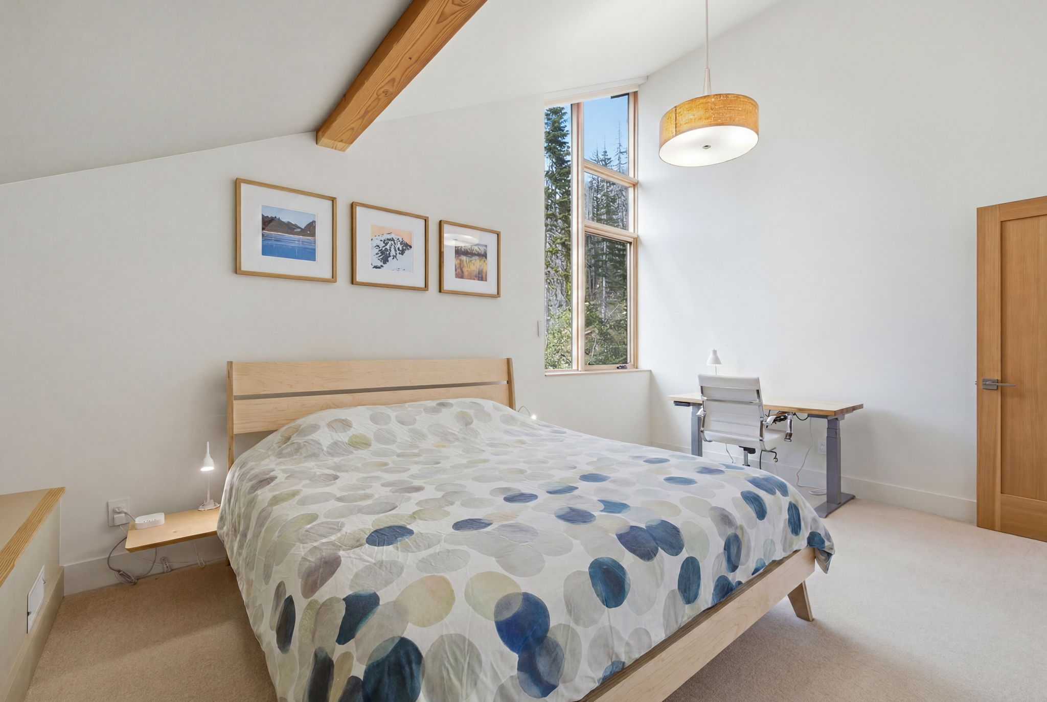 Guest bedroom with queen bed and sit-to-stand desk