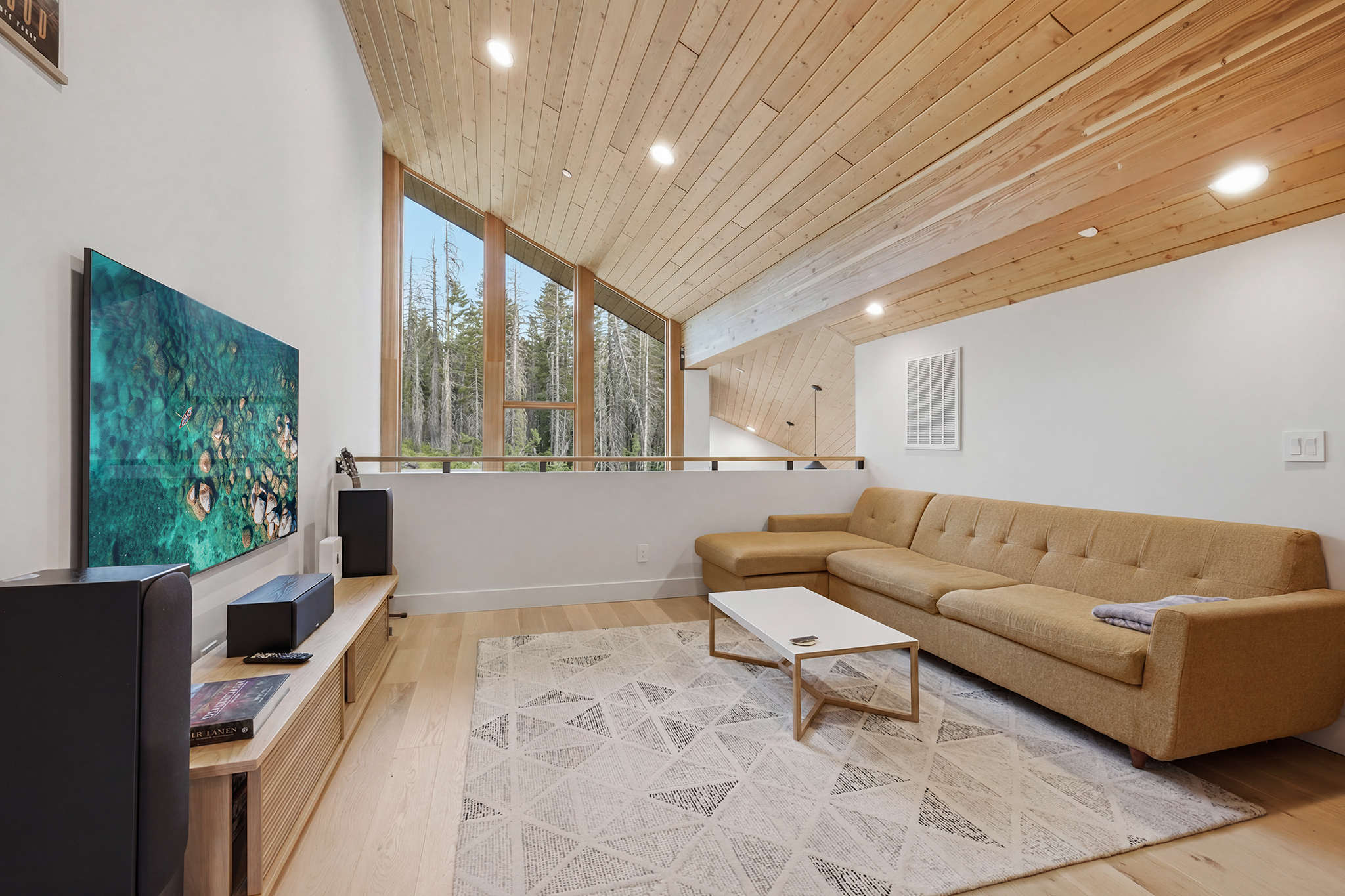Loft with large TV, sectional sofa, and cedar plank ceiling