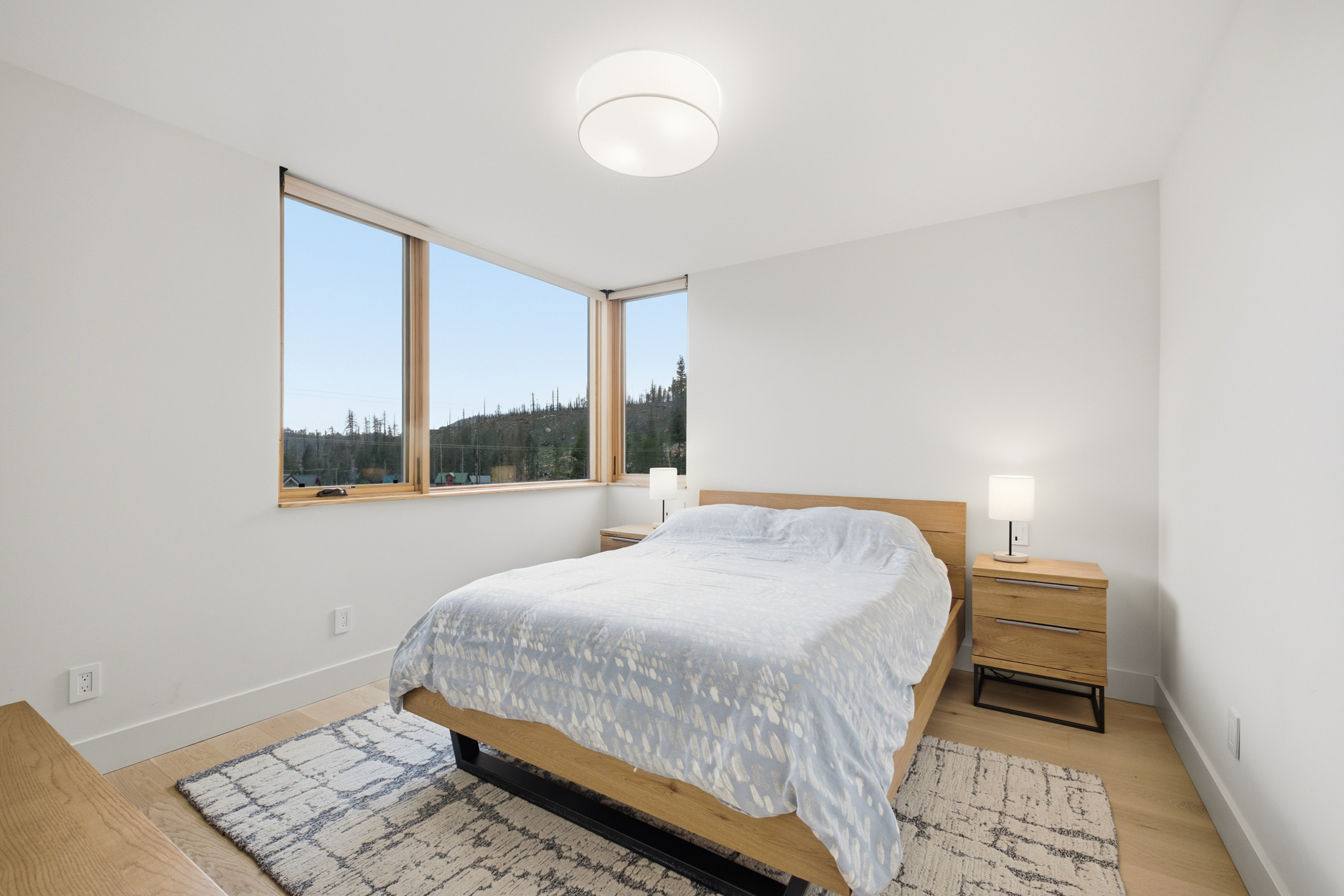 Ground floor bedroom with queen bed and corner windows