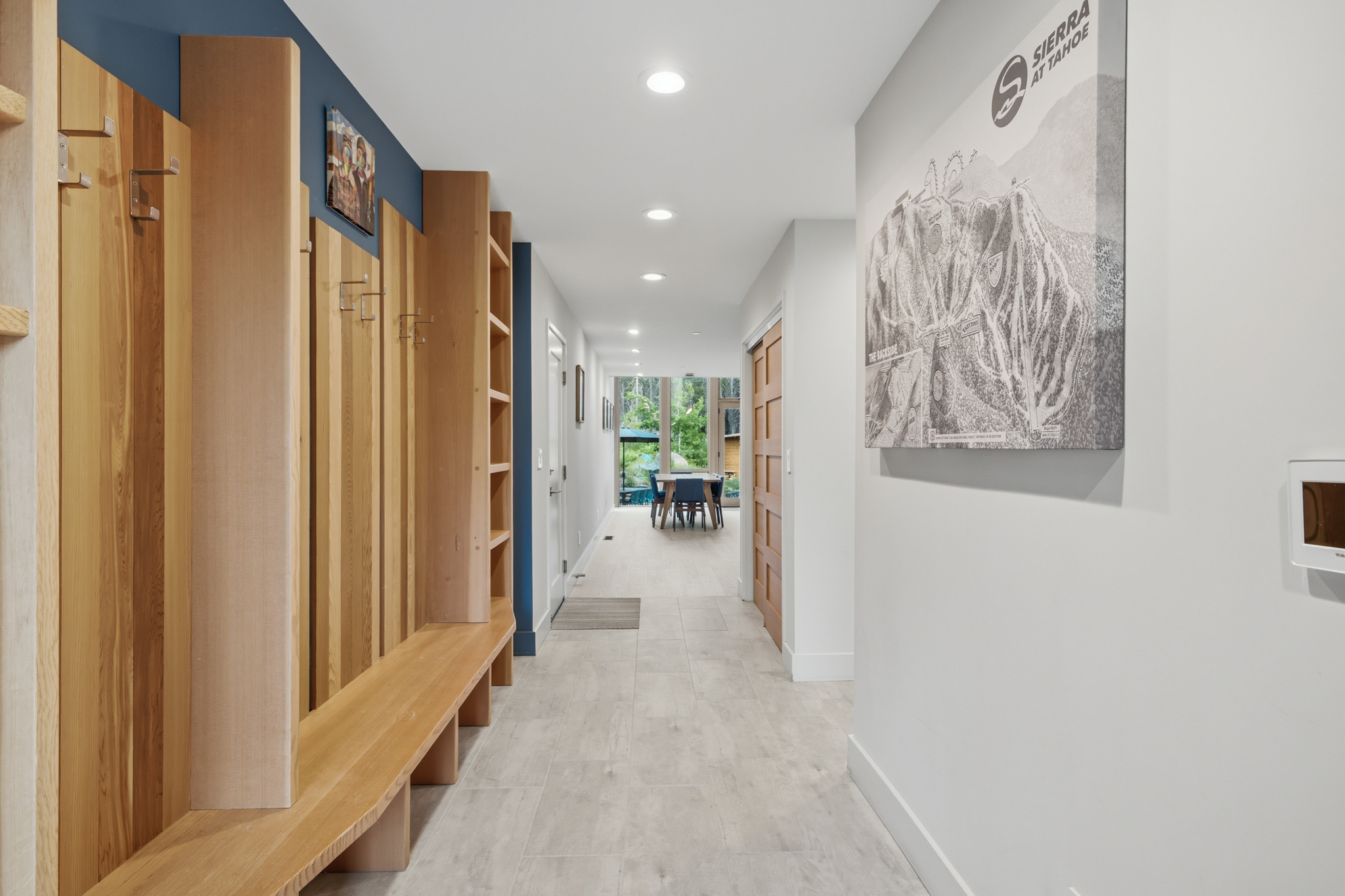 Mudroom with built-in wood lockers, bench, and Sierra-at-Tahoe trail map art
