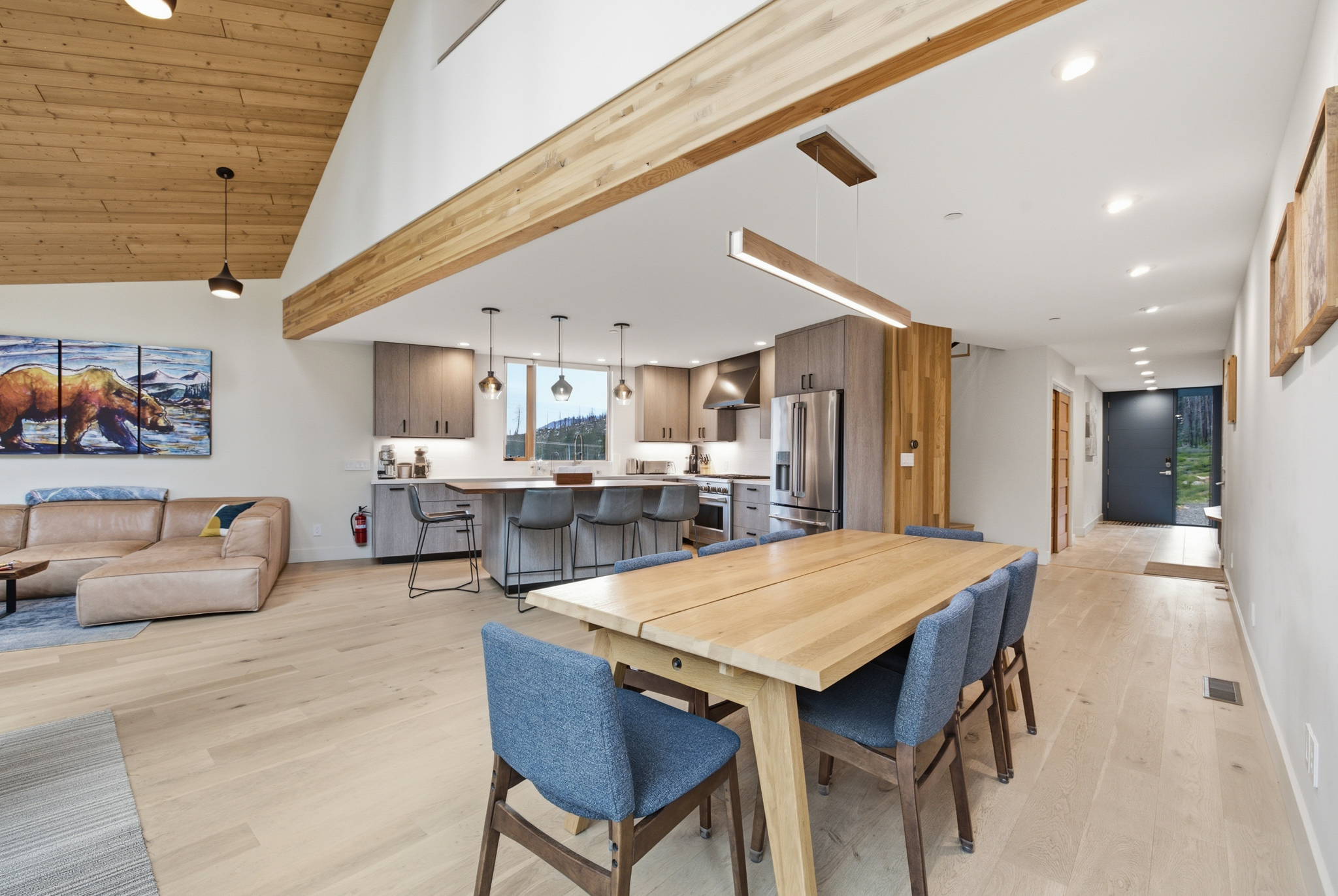 Open plan dining table with kitchen and living room visible behind