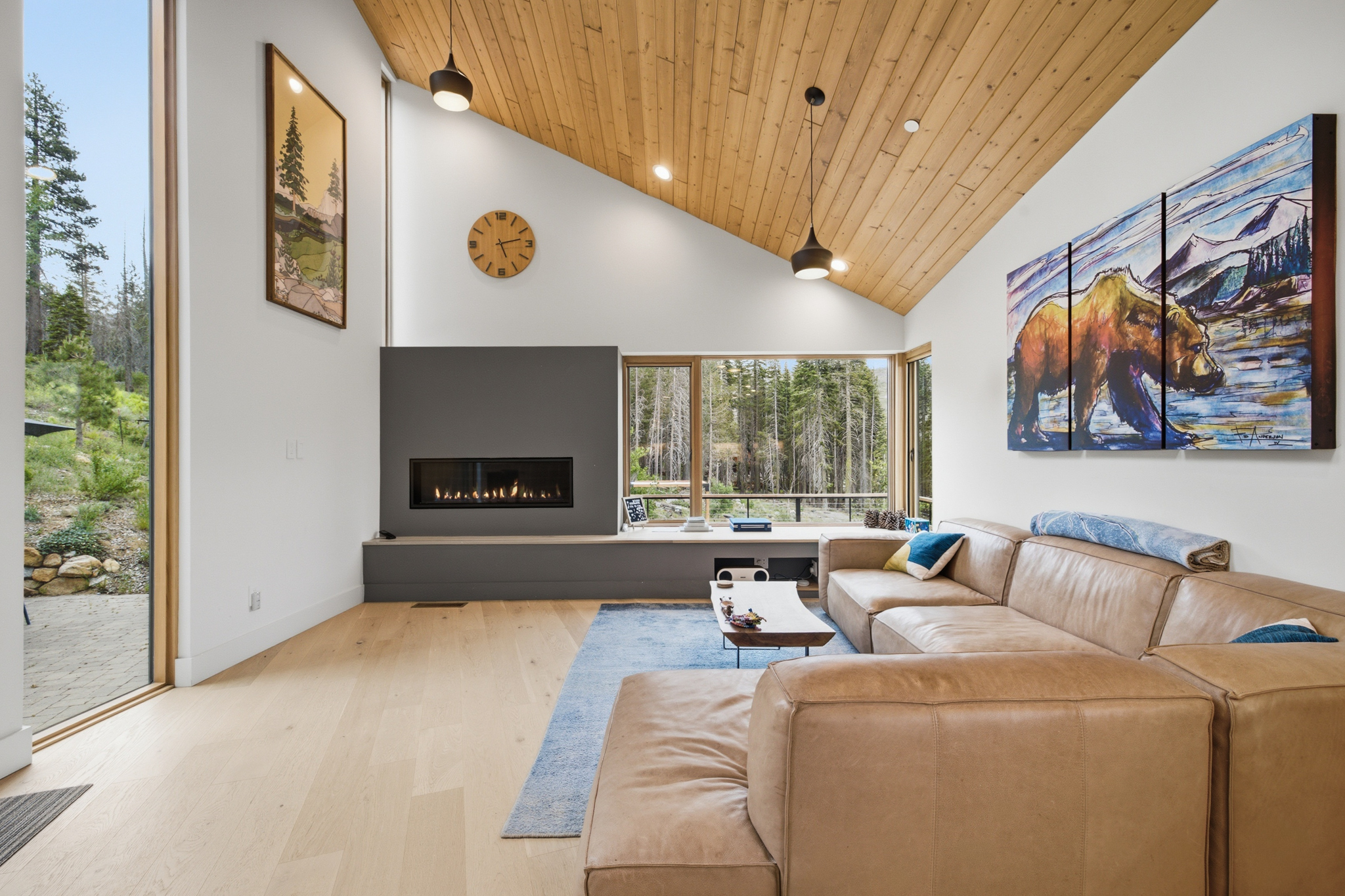 Living room with gas fireplace, leather sectional sofa, and bear painting