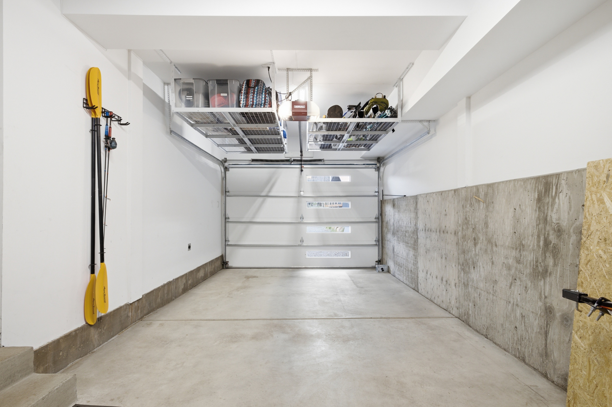 Garage interior with storage shelving and kayak paddles on wall