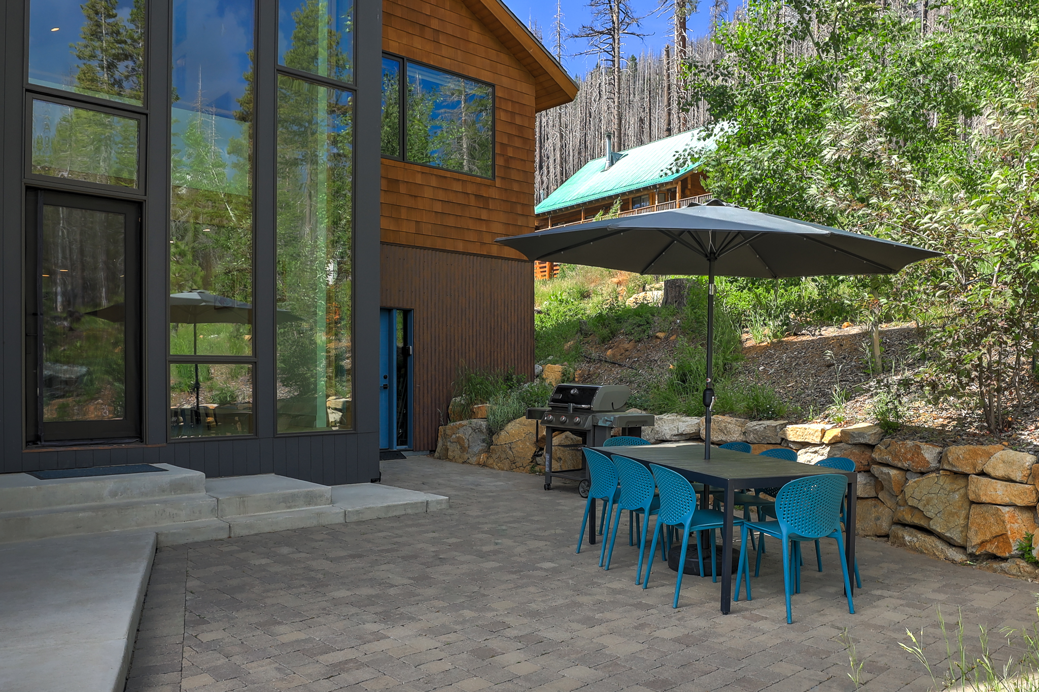 Back patio with outdoor dining furniture and view of the house windows