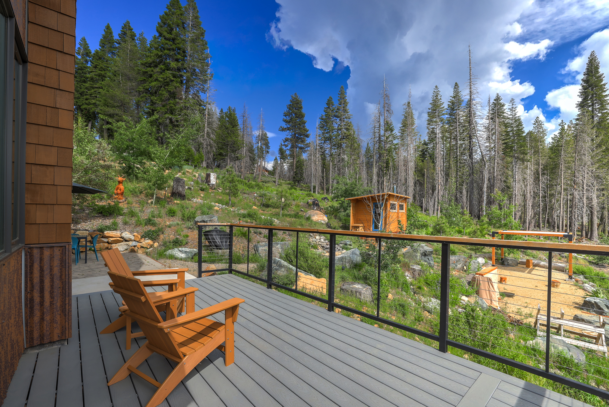 Deck with Adirondack chairs overlooking the forest