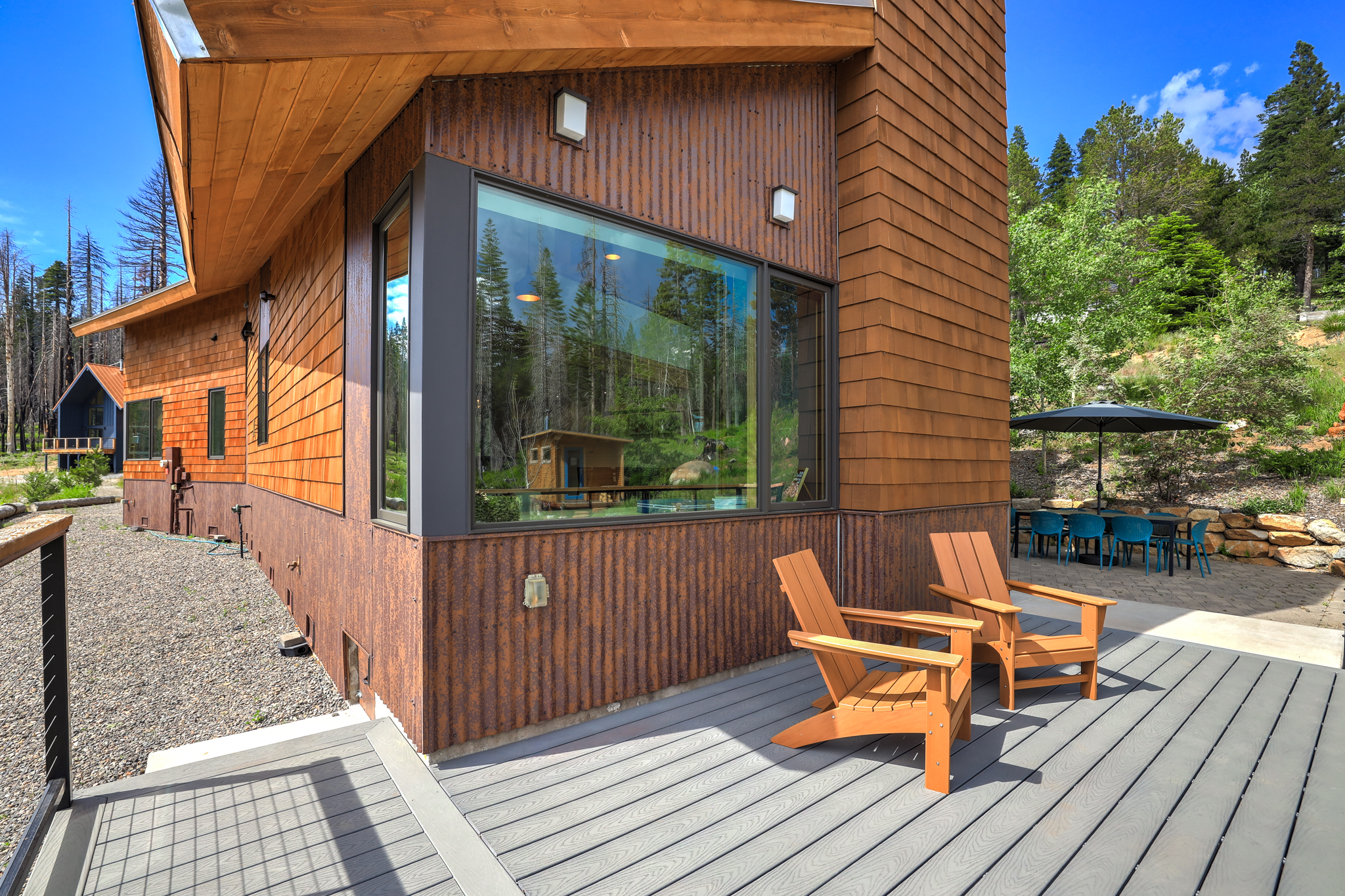 Side view of deck with Adirondack chairs and patio below