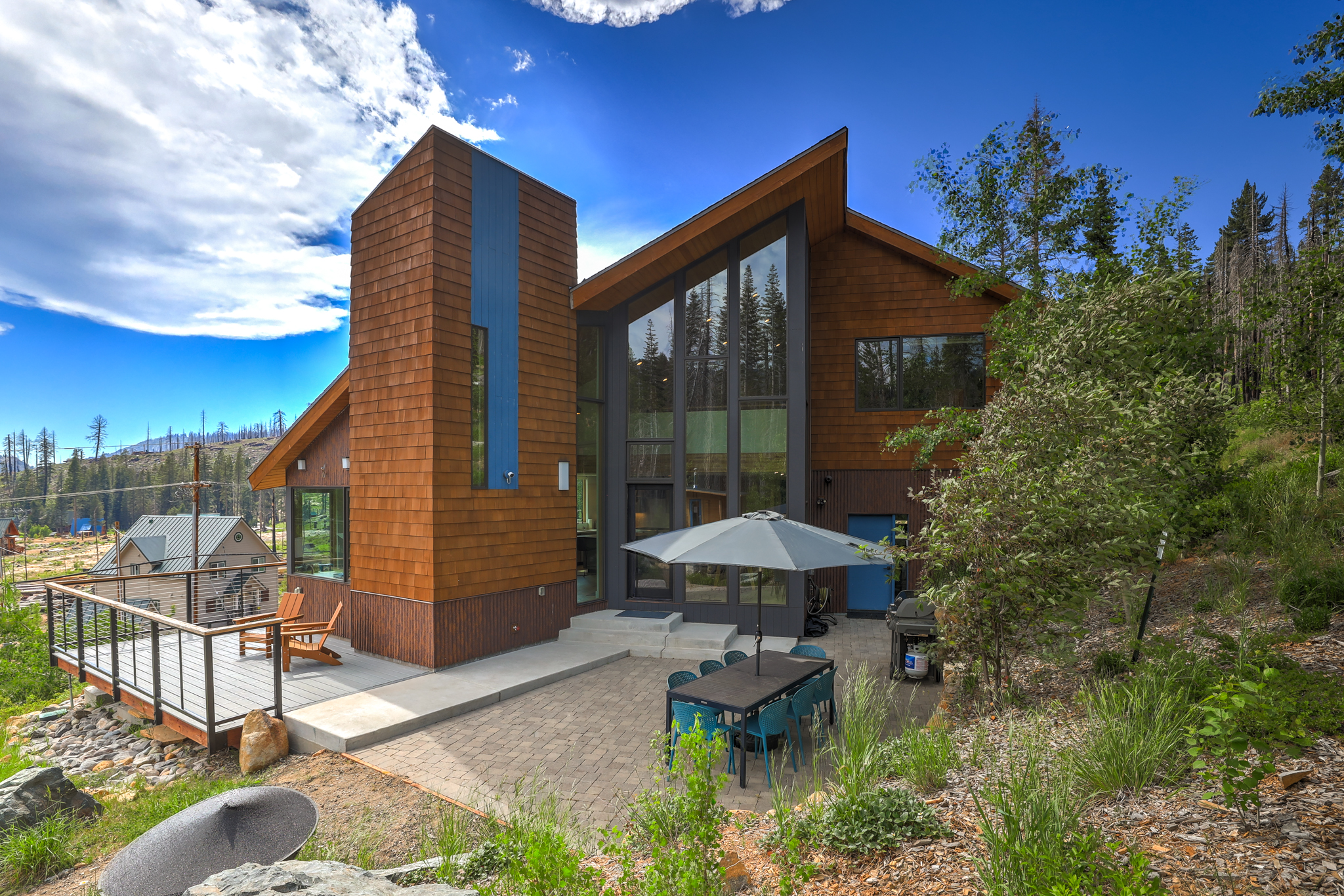Rear exterior of the chalet with deck and patio in summer